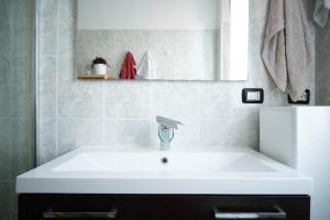 een badkamer met een witte wastafel en een spiegel bij Casa Tricy B&B in Bologna