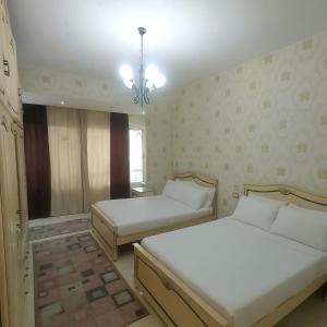 ein Schlafzimmer mit zwei Betten und einem Kronleuchter in der Unterkunft سبورتنج 5 in Alexandria
