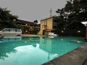a swimming pool with a car parked next to a building at Puri Senggigi Hotel in Senggigi