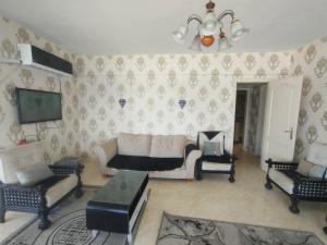 ein Wohnzimmer mit einer Couch und zwei Sesseln in der Unterkunft سبورتنج 5 in Alexandria + 1 Foto