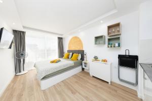 Un dormitorio con una cama y un televisor de pantalla plana. en Apart hotel Ponderosa with a pool & view, studio 226, en Playa Fañabe