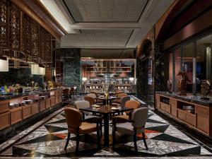 a restaurant with a table and chairs and a bar at Swissôtel Nusantara in Penajam