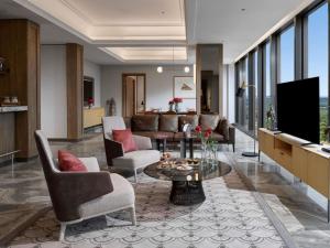 a living room with a couch and a tv at Swissôtel Nusantara in Penajam