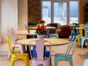 沙泰勒罗greet Hotel Chatellerault的一张桌子,上面摆放着五颜六色的椅子和一张桌子,上面摆放着鲜花