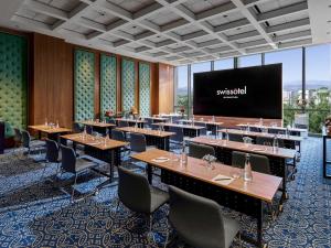 a conference room with tables and a projection screen at Swissôtel Nusantara in Penajam +36 photos