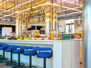 a bar with blue bar stools in a restaurant at TRIBE Paris Clichy in Clichy +70 photos
