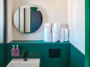 a bathroom with a sink and a mirror at TRIBE Paris Clichy in Clichy +69 photos