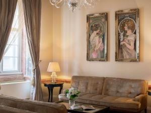 a living room with a couch and two paintings on the wall at The Mozart Prague in Prague +110 photos