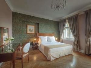a bedroom with a large bed in a room with green wallpaper at The Mozart Prague in Prague +108 photos