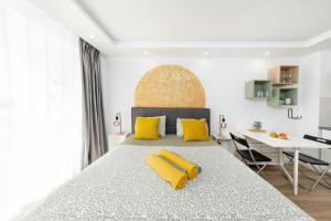 Un dormitorio con una cama grande con almohadas amarillas. en Apart hotel Ponderosa with a pool & view, studio 226, en Playa Fañabe
