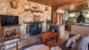 Una sala de estar con una pared de piedra con chimenea. en Casa Perdi Riogordo by Ruralidays, en Ríogordo