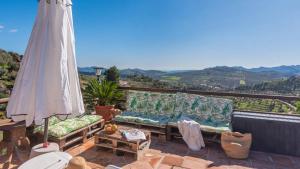 un patio con sofá y sombrilla en Casa Perdi Riogordo by Ruralidays, en Ríogordo