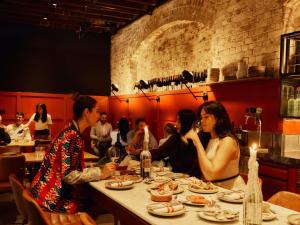 un groupe de personnes assises à une table dans un restaurant dans l'établissement Hotel Woolstore 1888, Sydney - Handwritten Collection, à Sydney