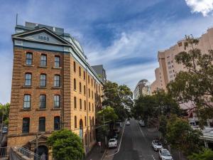 a tall brick building on a city street at Hotel Woolstore 1888, Sydney - Handwritten Collection in Sydney