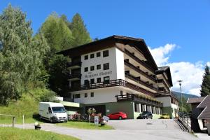 ein Gebäude mit einem Van davor in der Unterkunft Apartments at Berghaus Glockner in Heiligenblut