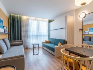 una sala de estar con un sofá y una mesa en Aparthotel Adagio Access Brussels Airport, en Machelen