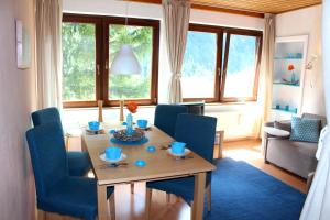 a living room with a table and blue chairs at Apartments at Berghaus Glockner in Heiligenblut