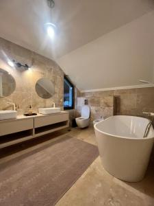 Garden Retreat Keyhouse في برانْ: حمام مع حوض ومغسلتين ومرحاض +97 صورة