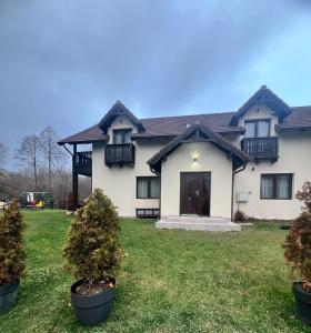 Garden Retreat Keyhouse في برانْ: أمامه منزل به شجرتين خزاف