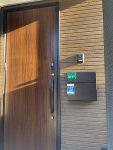 uma porta de madeira com um sinal verde em 福岡旅路 博多住吉包棟民宿 3號館 em Fukuoka