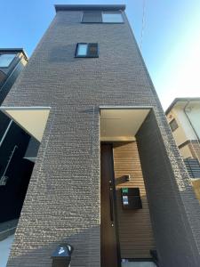 um edifício de tijolos alto com uma porta em frente em 福岡旅路 博多住吉包棟民宿 3號館 em Fukuoka