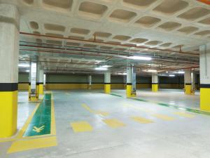 an empty parking garage with yellow and green markings on the floor at ibis Styles Istanbul Kurtkoy in Istanbul