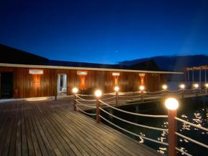a building with lights on a dock at night at Sea Plus Water Challet in Semporna