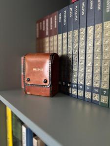 Casa Roberta - Esperienze di campagna في ريجيو إيميليا: محفظة موضوعة على رف بجوار الكتب +56 صورة