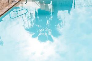 una piscina con reflejo en el agua en Apart hotel Ponderosa with a pool & view, studio 226, en Playa Fañabe