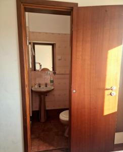 a bathroom with a sink and a toilet and a mirror at Anoitecer Itinerante AL - antiga residencial o garfo in Ponte de Lima