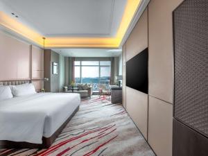 ein Hotelzimmer mit einem Bett und einem Wohnzimmer in der Unterkunft Mövenpick by Accor Xuzhou in Xuzhou