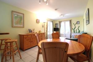 un salon avec une table et des chaises en bois dans l'établissement Appartement Le Chalet Vert proche lac randonnées, à La Bresse