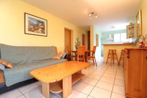 un salon avec un canapé et une table dans l'établissement Appartement Le Chalet Vert proche lac randonnées, à La Bresse