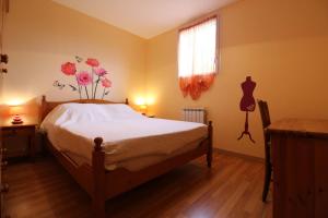 - une chambre avec un lit et une fenêtre ornée de fleurs sur le mur dans l'établissement Appartement Le Chalet Vert proche lac randonnées, à La Bresse