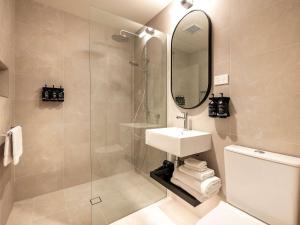Un baño con lavabo y ducha con espejo. en Mantra Shepparton, en Shepparton 12 fotos más