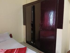 a wooden cabinet in a room with a bed at Coorg villas & homes in Madikeri