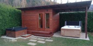 a small wooden house with a bath tub in a yard at Wellness chata BABÍ VRCH in Trojanovice