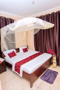 ein Schlafzimmer mit einem Himmelbett in der Unterkunft Ununio Beach Holiday Home in Daressalam