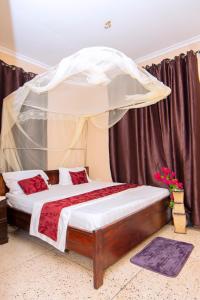 ein Schlafzimmer mit einem Himmelbett in der Unterkunft Ununio Beach Holiday Home in Daressalam