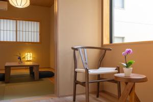 una silla en una habitación con mesa y ventana en 難波站走路8分鐘包棟別墅 絕佳地理位置 最大16人, en Wada