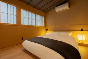 Un dormitorio con una cama grande y dos ventanas. en 難波站走路8分鐘包棟別墅 絕佳地理位置 最大16人, en Wada