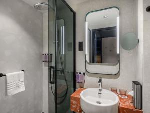 a bathroom with a sink and a shower and a mirror at TRIBE Budapest Airport in Budapest +186 photos
