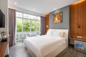 une chambre avec un grand lit et une grande fenêtre dans l'établissement LeParc Hotel - Ben Thanh Market, à Hô-Chi-Minh-Ville
