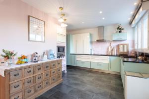 une grande cuisine avec des placards bleus et blancs dans l'établissement Maison de L'Apothicaire, à Montaigu-Vendée