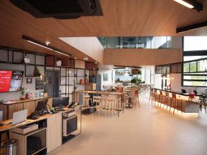 une grande cuisine et une salle à manger avec des tables et des chaises dans l'établissement ibis Tangará Da Serra, à Tangará da Serra