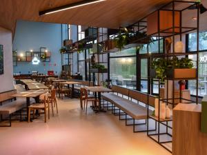 un restaurant avec des tables, des chaises et des fenêtres dans l'établissement ibis Tangará Da Serra, à Tangará da Serra