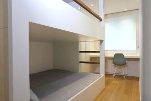 Ce lit se trouve dans un dortoir doté d'une fenêtre et d'une chaise. dans l'établissement Appartement 6 personnes moderne & épuré vue latéral mer à Knokke avec parking by La Conciergerie, à Knokke-Heist