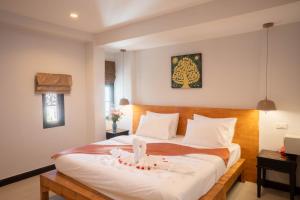 sypialnia z dużym białym łóżkiem z drewnianym zagłówkiem w obiekcie TJR Boutique hotel w mieście Chiang Mai