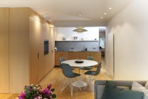 une cuisine et un salon avec une table et des chaises dans l'établissement Appartement 6 personnes moderne & épuré vue latéral mer à Knokke avec parking by La Conciergerie, à Knokke-Heist