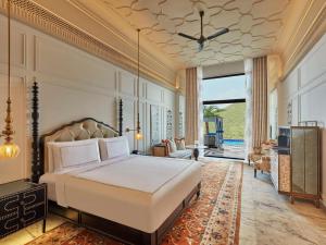 a bedroom with a bed and a living room at Fairmont Udaipur Palace in Udaipur +182 photos